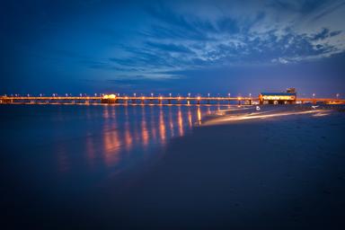 Long-exposure dusk view of a pier over the water (Gulf State Park pier image used as a background on the park page) — attractive scenic shot of a notable on-site landmark.