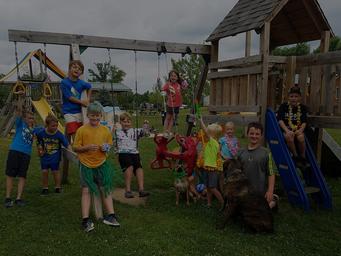 Playground scene with children and a play structure — demonstrates onsite family amenities and activity areas. Comes from the site's on-site amenities/gallery images.