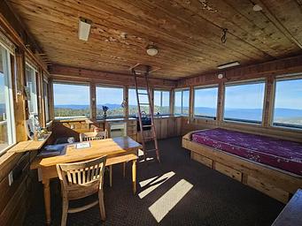 interior of a lookout, with bed, table and chair