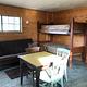 Cabin interior showing futon couch, bunkbeds and kitchen table