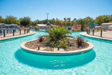 Ground-level view of the lazy river and central pool area — useful for gallery to show water amenity scale and design. Sourced from the property’s site and matches the resort’s waterpark features.