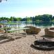 Clear waterfront campsite view showing picnic table, grill and lakefront scenery — matches Amenities page image and illustrates the park’s lakeside camping area (source page: /amenities/).