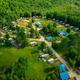 Aerial overview showing campground layout, RV sites, central pool/building and surrounding woods — good overall property perspective (source: homepage drone image).