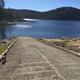 Boat launch/boat ramp leading into the lake with surrounding shoreline and hills — useful facility view (appears on camping/lodging pages).