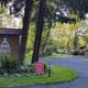 Entrance/office area with Kamp Klamath sign, kiosk and surrounding grounds — useful for orientation and arrival impression; from the amenities/landing page.
