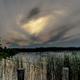 Lakeshore view framed by reeds and dock posts at dusk — illustrates the waterfront environment and natural setting available at the property (homepage gallery image).