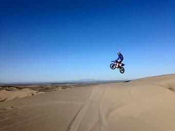 Motorcyclist jumps a dune