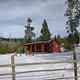 High Rye Cabin, view from parking lot,  Red Cabin with snow on the ground surrounded by green trees
