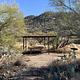 Picnic table outside of the ramada, with a standing grill