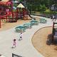 Elevated view of a large, permanent playground area with picnic tables and surrounding landscaping — clearly an on-site family recreation facility; sourced from the resort’s facilities photo gallery page.