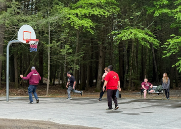 Outdoor recreation area showing a basketball court and surrounding woods; from the site's 'Recreation Areas / sports' image — useful to show activity spaces on the property.