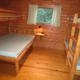 Interior of a small wood cabin showing bunk beds and a larger bed — useful for the property's cabin/lodging gallery (from the campground 'ways to stay' photos).