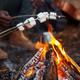 Close view of people roasting marshmallows over a campfire — depicts on-site family camping activities and appears on the resort’s Camping Activities page.
