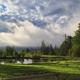 Scenic view of the property's pond and treeline with dramatic clouds — represents the lake/landscape scenery that gives the campground its name and appears on the site's gallery.