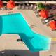 Top-down aerial of the pool deck with umbrellas and lounge chairs — good overhead amenity shot for the gallery and appears on the site.