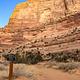 A dirt road with a sign for Campsite 26 leads towards the base of an orange sandstone cliff