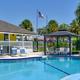 Sparkling blue swimming pool and poolside lounge chairs at Sundance Lakes RV Resort.