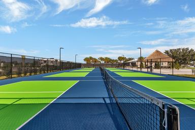 Image of multiple bright green/blue pickleball/tennis courts on-site—useful amenity shot from the Gallery confirming on-property courts.