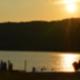 Lakeside sunset with people on the shore — good scenic view of the campground’s waterfront setting; appears on the site’s main page.