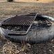 Metal fire pit on the ground at Calabasa campground. Metal ring with an attached metal grill on top.