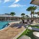 Clear ground-level photo of the resort-style pool, surrounding deck chairs and clubhouse in background—matches homepage/gallery pool images and highlights the main amenity area.