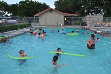 Swimming pool in use with surrounding pool facilities — illustrates the campground's pool amenity (matches recreation/gallery photos on the site).