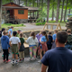 Exterior view of campground grounds with a cabin/pavilion and children gathered at an activity — shows on-site facilities and family programming (from the Birthdays page).