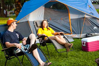 Tent camping scene showing tent, chairs and grassy campsite — represents tent site accommodation and campground atmosphere (from ‘tent sites’ gallery context).