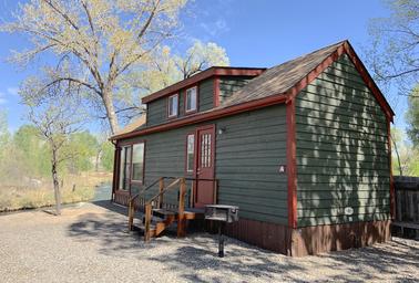 High-resolution exterior photo of a deluxe cabin (clear building, steps, grill and surroundings) from the 'Ways to stay' / cabins pages — good cabin property shot.