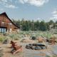 Cabin/lodge exterior with a firepit seating area and natural landscape — shows guest accommodation and communal outdoor space on the property (appears on the property's main gallery).