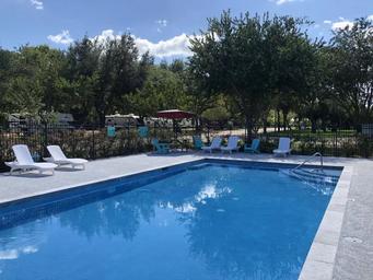 Outdoor swimming pool with lounge chairs and RVs visible beyond the fence—shows a key guest amenity and nearby RV sites from the site's gallery.