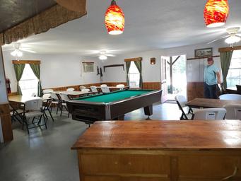 Interior clubhouse common room with pool table and seating — facility photo from the gallery that demonstrates on-site amenities and gathering space.