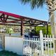 Covered outdoor pavilion/Tiki-bar area with fencing and seating — shows a social/amenity space guests can use (matches images of on-site clubhouse/bar area).