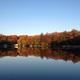 Scenic lake reflection at sunrise/sunset with tree-lined shore and docks — good for showcasing the campground's natural scenery and waterfront appeal (source: Visit Us page).