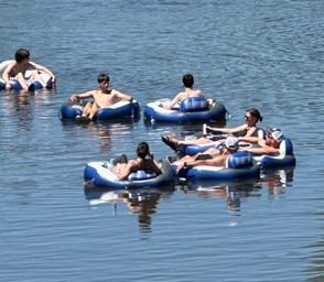 Image of tubing on the water (people on inner tubes) — illustrates lake/river recreational activity available at the resort; matches tubing/ waterfront content on the site.