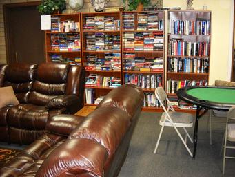 Community library/lounge with shelving and seating — shows indoor common-area amenities available to guests (source page: Amenities).