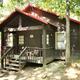 Exterior of a rustic cabin with a porch — shows on-site cabin accommodation option and wooded campsite setting (labeled cabin image on the resort page).