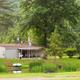 Campground office/grounds building with flagged lawn and pond in foreground — useful facilities/exterior shot from the Facilities page.