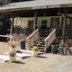 Photo shows the campground’s main office/porch area with 'Peppertree Camping' sign on the building — a clear on-property facility image from the site’s homepage (slide04b).