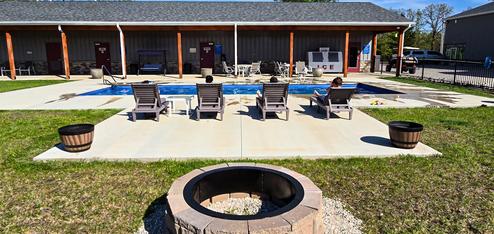 Pool and patio area with lounge chairs and the clubhouse/restroom building visible behind it; taken from the Amenities page and shows on-site recreation facilities.