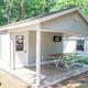 Exterior view of a rustic cabin with covered porch and picnic table — clearly shows the cabin lodging offered (from the cabin rentals gallery).