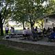 Large Group of people at campsite picnic tables.