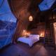 Interior photo of a glamping dome showing bed, loft and exterior view through dome panels — highlights interior amenities and star-viewing feature (source page: homepage/accommodation images).
