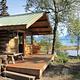 An exterior view of Priest Rock Cabin with Lake Clark in the background