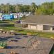 Panoramic view of playground and nearby RV sites with restroom/utility building visible — highlights onsite family amenities and site spacing.