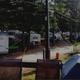 View showing multiple RVs and campsite rows among pine trees, electrical/utility poles visible — good depiction of the RV park layout and density (homepage slider context).