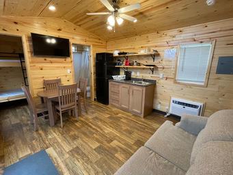 Interior view of a cabin living area/kitchen showing furnishings and finishes — supports the cabins listing and gives guests a clear sense of interior accommodations.