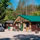 Campground office/building exterior with parking and surrounding trees — useful for showing on-site facilities and check-in area.