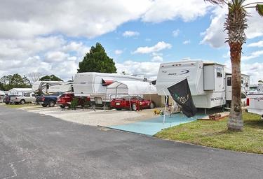 Wide view of multiple RV sites and paved drive aisles with palm trees — useful overview of typical RV pads at Barrington Hills as shown in the resort photo set on the page.