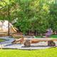 Another campsite composition with tent, firepit and seating that highlights the wooded setting and site layout; from the glamping page (100_tg2_5625).